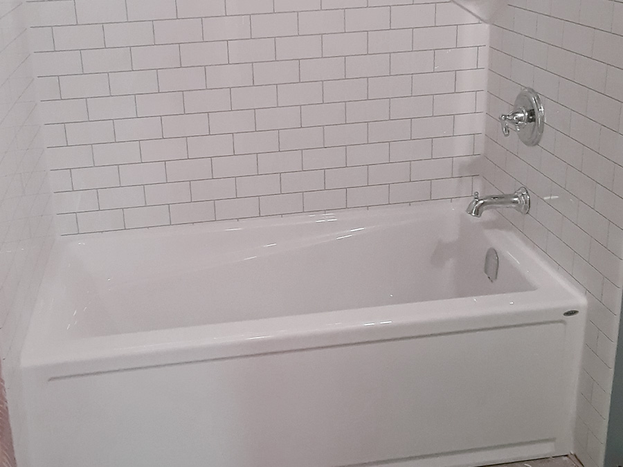 Installed bathtub replacement with acrylic surround in modern bathroom